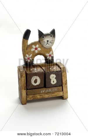 Wooden calendar with a cat who is standing on it.