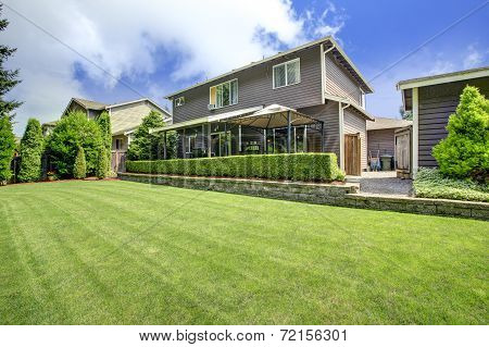 House Exterior With Lawn And Trimmed Hedges