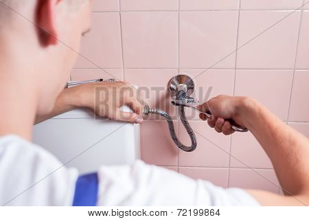 Plumber Fixing Toilet With Wrench
