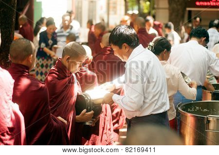 Peoples Giving With  Alms To A Buddhist Monk In Myanmar.