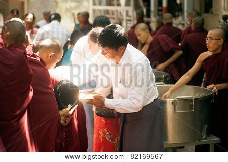 Peoples Giving With  Alms To A Buddhist Monk In Myanmar.