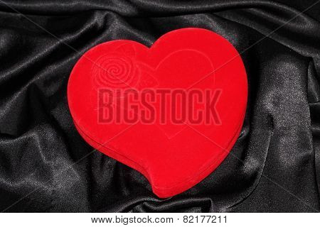 Heart-shaped jewelry casket placed on a black silk