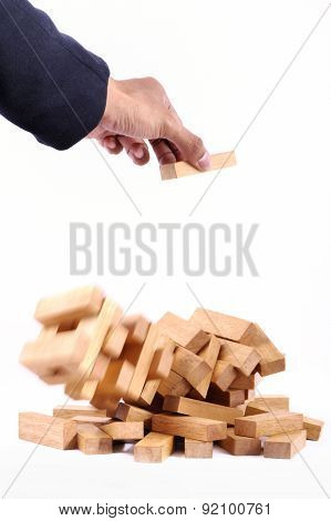 Businessman Playing With The Wood Game (jenga). On White Background.