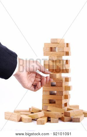Businessman Playing With The Wood Game (jenga). On White Background