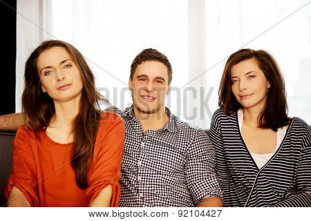 Sisters and brother sitting on the sofa.