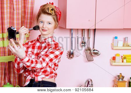 Pretty pin-up girl teenager smarten up on a pink kitchen. Beauty, youth fashion. Pin-up style.