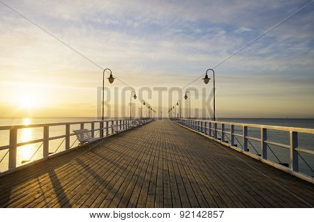 The wooden pier on the sea at sunrise