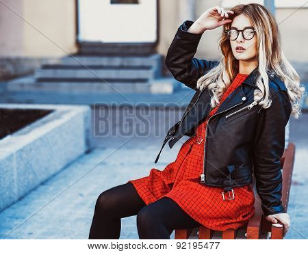  Girl Sitting on Bench. Street Fashion. Urban Lifestyle. Young Beautiful Woman Walking Outdoor.Image toned.