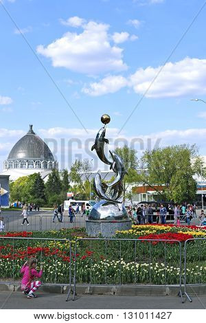 MOSCOW, RUSSIA - MAY 7, 2016: Monument to the dolphins playing with a ball near a building of Moskvarium - Moscow oceanarium with marine animals