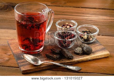 Tea composition with old spoon on wooden table