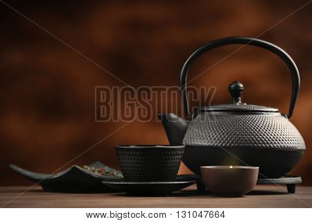 Black pialats and teapot on blurred background