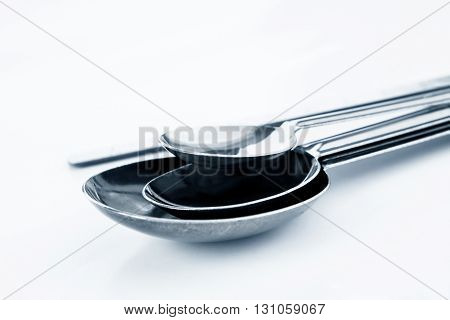 the Group of Steel measuring spoons and Stirring Rod kitchen equipment on white background