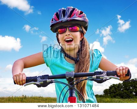 Bikes bicycling child. Girl rides bicycle. Girl wearing sport colored sunglasses. Cyclist look up.