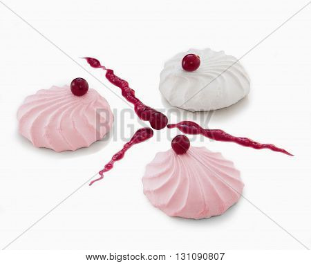 Three marshmallow on a table decorated with cranberries