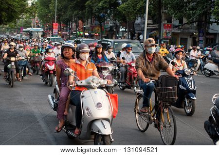 Ho Chi Minh city, Vietnam - April 19, 2015 : crowed scene of city traffic in rush hour, crowd of people wear helmet, transport by motorcycle, stop at red light in stress situation, Vietnam