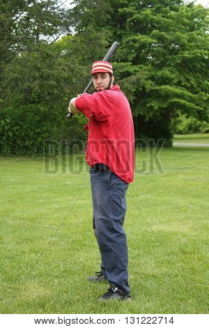 OLD BETHPAGE, NEW YORK - MAY 22, 2016: Baseball player in 19th century vintage uniform during old style base ball play following the rules and customs from 1864 in Old Bethpage Village Restoration