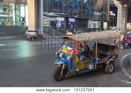 BANGKOK THAILAND - APR 17 : tuktuk is parking on sidewalk of siam square in evening time on april 17 2016 thailand. tuktuk is popular taxi service of tourists in bangkok