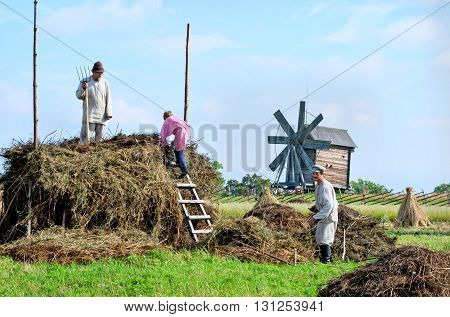 KIZHI RUSSIA - AUG 07 2015: People in national costumes work in the field on the island Kizhi Rusia
