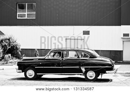 Podol, Ukraine - May 19, 2016: View Of Goes On Road Classic Car Gaz-12 Zim With Driver And Passenger
