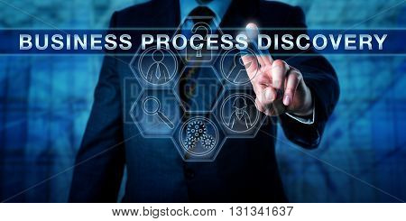 Manager pushing BUSINESS PROCESS DISCOVERY on a virtual touch screen interface. Business metaphor. Information technology concept for techniques used to collect data and analyse current operations.