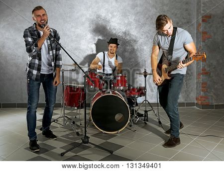 Musicians playing musical instruments and singing songs in a studio