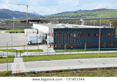 Dolny Hricov Slovakia - April 13 2016: Logistics center of international parcel delivery company DPD freight is uncharged from van. Tower cranes in background