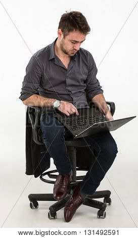 man sitting in a chair with a laptop in hand. studio white background