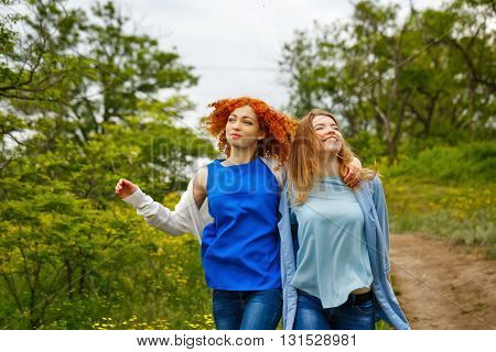 Best friends forever. Girlfriends strolling arm in arm in the park. BFF. Close friends. Gentle friendship.