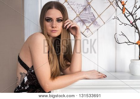 Beautiful blonde young woman wearing fashionable clothes in room