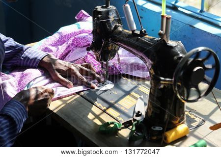 KUMROKHALI, INDIA - FEBRUARY 13: Man is working with sewing machine in Kumrokhali, West Bengal, India on February 13, 2014