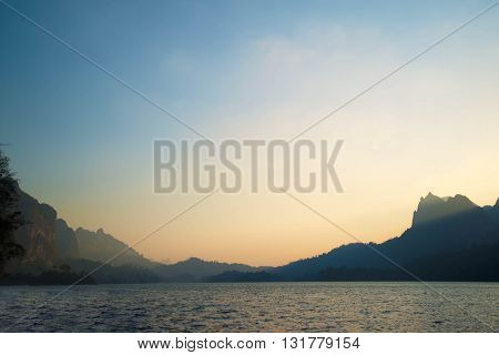 Beautiful sunset and sunbeam between mountain sunray at mountain and sea Golden sunray at Suratthani Thailand. Sunray at evening