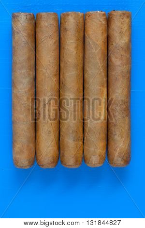Detail of luxury Cuban cigars on the blue table