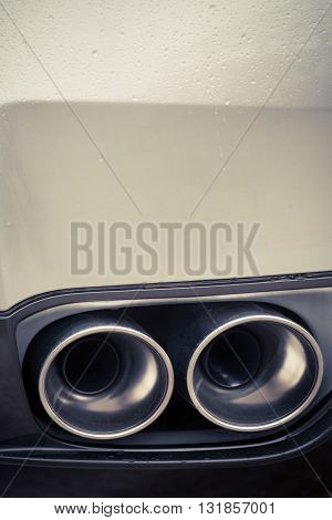 Close up shot of a car's double exhaust pipe.