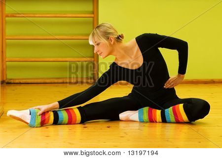 Ballerino di balletto facendo esercizio stretching su un piano