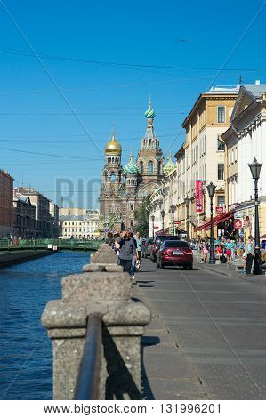 Saint Petersburg Russia - August 23 2015: Embankment of Griboyedov Canal Italian Bridge Church of the Savior on Blood (Cathedral of the Resurrection of Christ 1883-1907 by Alfred Parland) and passers-by.
