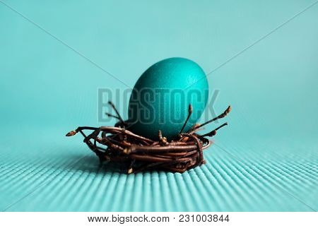 Easter Egg In The Nest On Blue Background