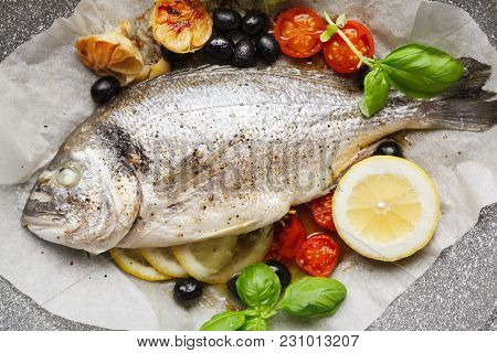Fish Gilt-head Bram, Cooked In A Pan With Vegetables And Lemon, Black Olives. Fresh Basil . Healthy 