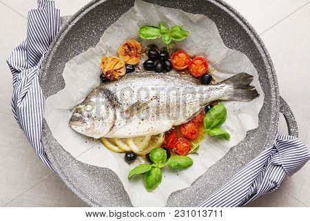 Fish Gilt-head Bram, Cooked In A Pan With Vegetables And Lemon, Black Olives. Fresh Basil . Healthy 
