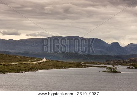 Loch Tollaidh, Scotland - June 9, 2012: Heavy Dark Brown Cloudscape Over Lake Colors Water As Brown.