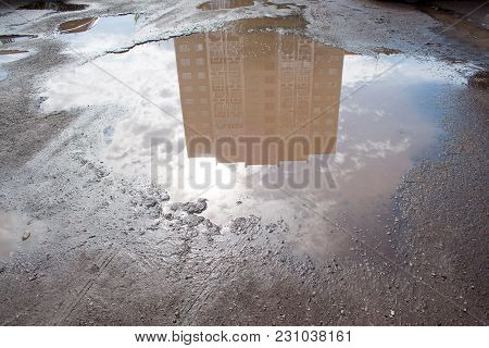 The Bad Asphalted Road With A Big Pothole Filled With Water. Dangerous Destroyed Roadbed. Mirror Ref