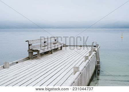 Norwegian landscape in gentle pastel colors. A wooden pier with a rest place. View of the Hardangerfjord Fjord. No far from the city of Oystese