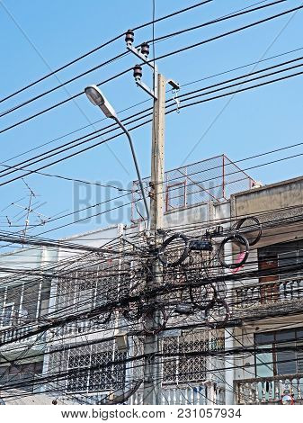 Nonthaburi, Thailand - March 14, 2018 : Disarrangement Of Electric Wire On Pole Near Building.