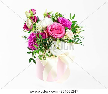 Composition Of Flowers In A Pink Hatbox. Tied With Wide White Ribbon And Bow.