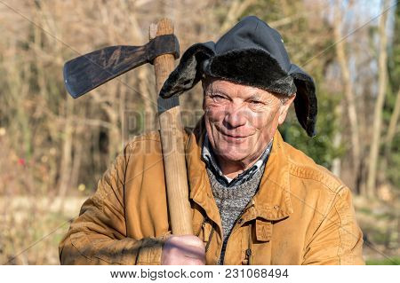 Portrait Of Senior Man With Ax Over His Shoulder.