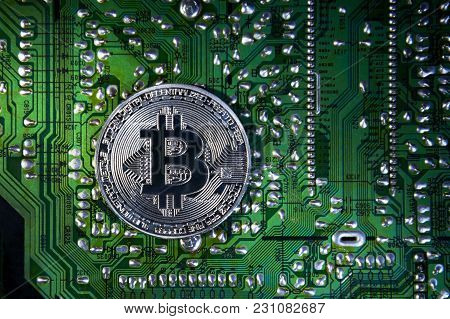 Silver Bitcoins On The Chip. The Green Background. Crypt Of Safety. Virtual Money. Mining