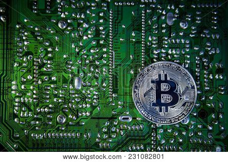 Silver Bitcoins On The Chip. The Green Background. Crypt Of Safety. Virtual Money. Mining