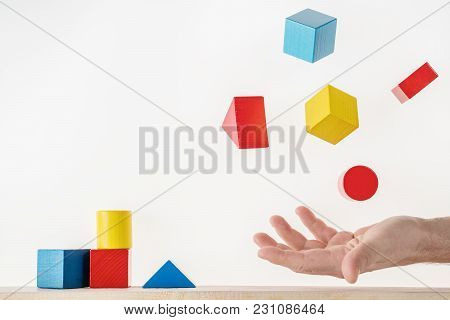 Male Hand Juggling Colorful Wooden Shapes. Concept Of Creative, Logical Thinking. Floating Shapes.