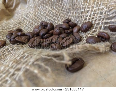 Coffee Beans On Sack Background. Closeup Photo