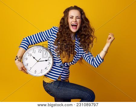 Cheerful Woman On Yellow Background With Clock Rejoicing
