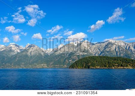 Fantastic view over ocean, snow mountain and rocks at Sechelt inlet in Vancouver, Canada.